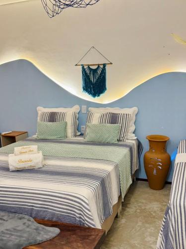 a bedroom with two beds with striped sheets at Pousada Varanda Amar - Icaraizinho de Amontada in Icaraí
