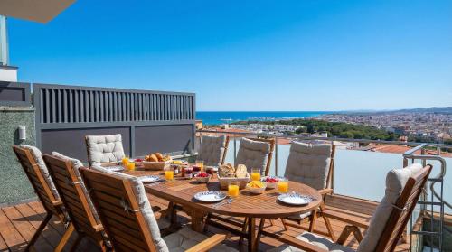 a table on a balcony with a view of the ocean at Villa Kala in Sant Pere de Ribes