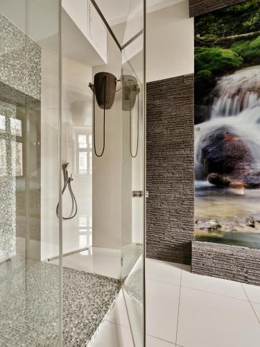 a bathroom with a shower with a painting on the wall at Hotel President in Bielsko-Biała