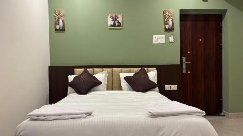 a bedroom with a large bed with white sheets and pillows at Waves Residency in Chennai