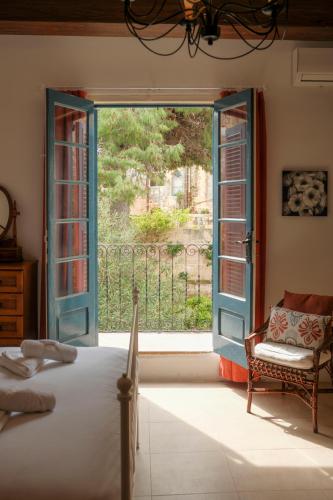 a bedroom with an open door to a balcony at Historic Villa with a Private Pool in Mosta