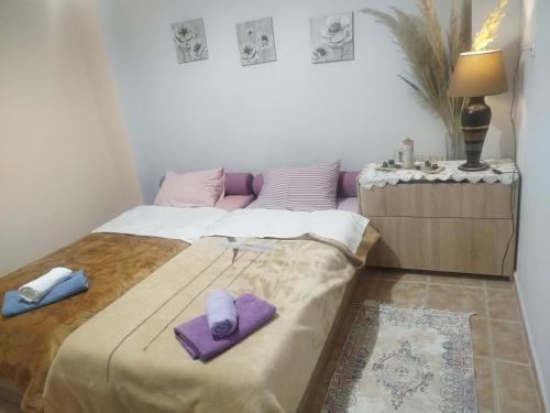 a bedroom with a bed with purple towels on it at Haras'house in Asvestokhórion