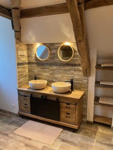 a bathroom with two sinks on a counter with mirrors at L'Auberge de Reullée in Marigny-lès-Reullée