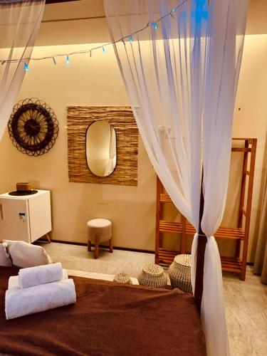 a bedroom with a bed with curtains and a mirror at Pousada Varanda Amar - Icaraizinho de Amontada in Icaraí