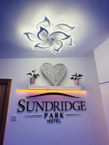 a sign for a sunburst park hotel with a heart on a wall at Modern Studio Apartments in Bromley, Greater London near Tesco and Sundridge Park Station in Bromley