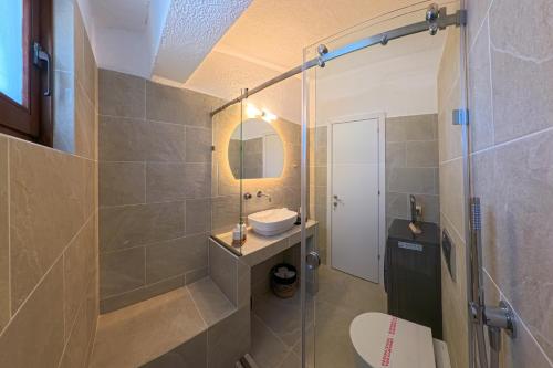 a bathroom with a toilet and a sink and a shower at Elani Blue Coast Maisonette in Elani