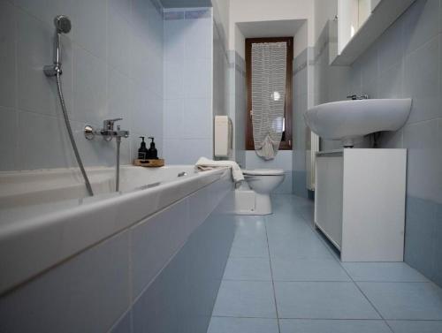 a white bathroom with a sink and a toilet at Slate House & Terrace - 6 min walk to Bernina Express in Tirano