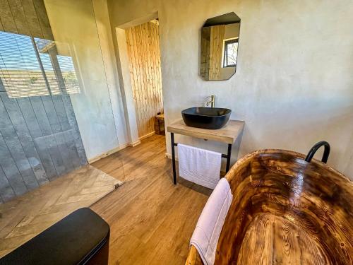 a bathroom with a sink and a bath tub at Bietjiedam's The Barn in Caledon