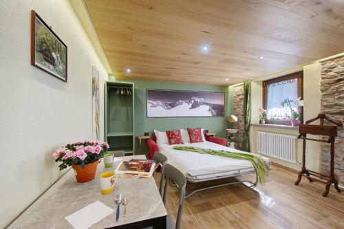 a bedroom with a bed and a table with flowers at Mes Anges Perloz in Pont-Saint-Martin