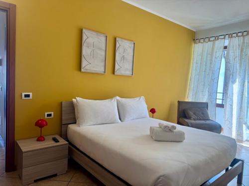 a bedroom with a large bed and a yellow wall at Slate House & Terrace - 6 min walk to Bernina Express in Tirano