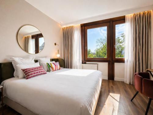 a bedroom with a large bed and a mirror at Hôtel Restaurant Vaillant -ouverture Spa de 1200m2 Octobre 2026 in Sélestat