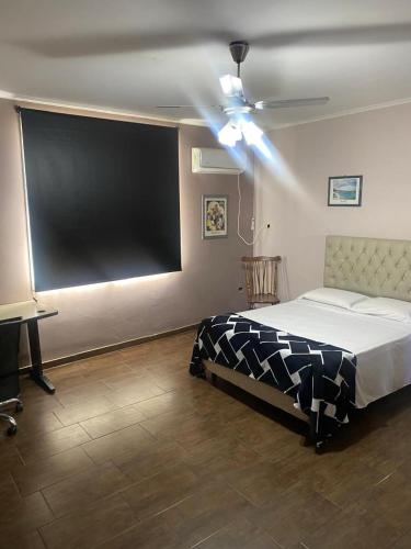 a bedroom with a bed and a large screen at Departamento cómodo y totalmente equipado, ideal para familias, grupos o viajes laborales in Santa Fe
