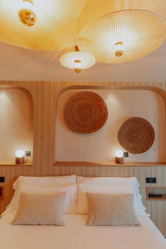 ein Schlafzimmer mit einem Bett, zwei Lampen und zwei Kissen. in der Unterkunft Hotel Meridional in Guardamar del Segura