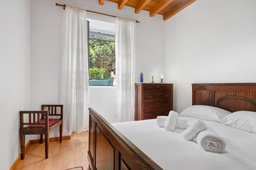a bedroom with a bed and a window and a chair at Casa Girasol in Faial da Terra