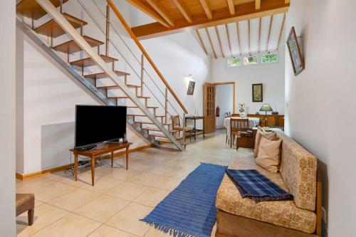 a living room with a couch and a staircase at Casa Girasol in Faial da Terra