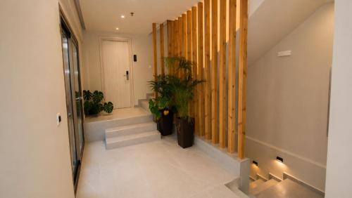 a hallway with stairs and potted plants in a building at Lunar Hotel Modern Boutique in Hersonissos