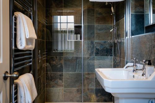 a bathroom with a sink and a shower at The Bull Inn in Woodbridge