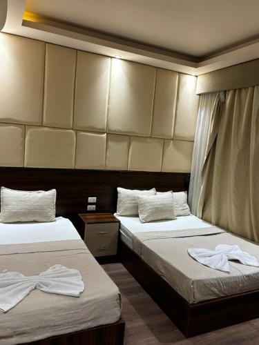 two beds in a hotel room with towels on them at Grand Elite Hotel in Cairo