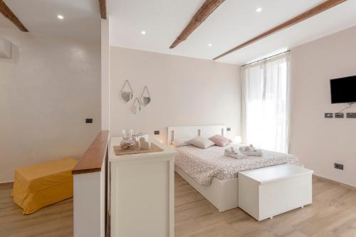 a white bedroom with a bed and a desk at The Hemme's Home in Genoa