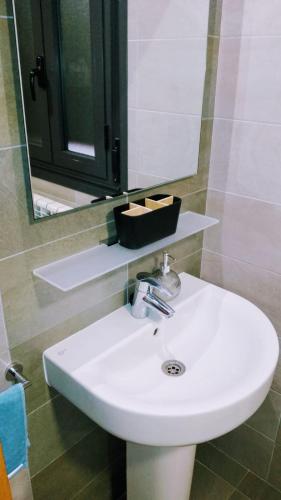 a white sink in a bathroom with a mirror at El Rincón del Ángel in Jaca