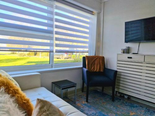 a living room with a couch and a chair and a window at Modern Newly Renovated Home on the Broads in Lowestoft