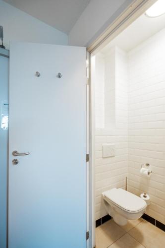 ein Badezimmer mit Toilette und Glastür in der Unterkunft The ASH in Antwerpen