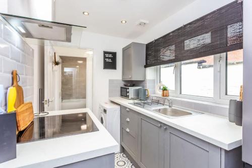 a kitchen with two sinks and a microwave at Boho Chic - Stylish Home in City Centre, Sleeps 4 in Darlington