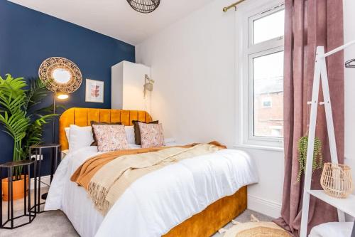 a bedroom with a bed with a blue accent wall at Boho Chic - Stylish Home in City Centre, Sleeps 4 in Darlington