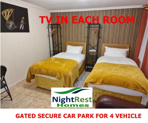 two beds in a room with a car park for vehicles at NightRest Homes 5 minutes to Luton Airport -Wifi - Free Parking -Luton in Luton