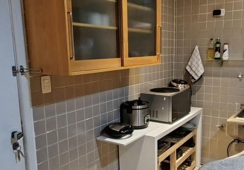 a kitchen with a counter with a microwave at Alphaville Serviced Apartment São Paulo in Barueri