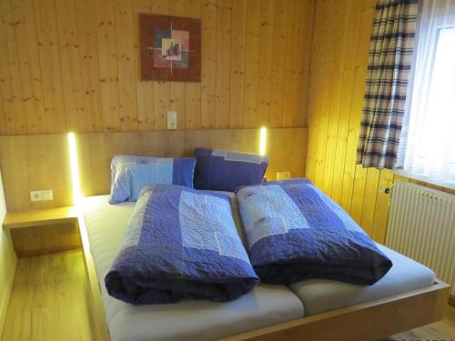 a bedroom with a bed with blue and white pillows at Ferienwohnung Birgit in Sankt Gallenkirch