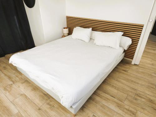a large white bed with white sheets and pillows at Maison cosy et élégante -Tram A et E à 300 m, - Bordeaux 15 min in Cenon
