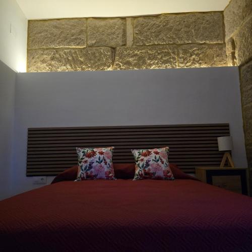 a bedroom with a large red bed with two pillows at Casa a Figueira in Pungín