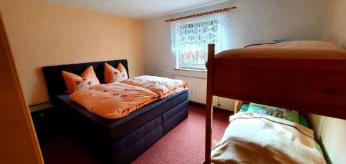 a bedroom with two bunk beds and a window at FEWO Aschbergblick in Klingenthal