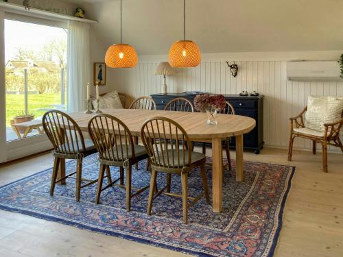 a dining room with a table and chairs on a rug at Charming House With A View Of The Sea in Båring