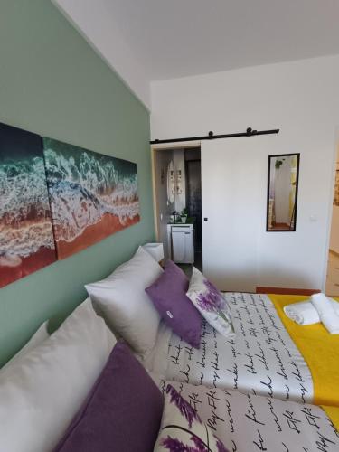 a bedroom with a large bed with purple pillows at Quarto Casa na Praia in Porches
