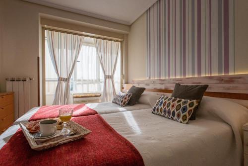 um quarto com uma cama grande e uma bandeja em Apartamentos River Santander em Santander