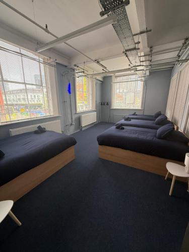 a room with four beds and two windows at napNQ in Manchester