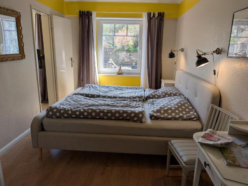 a bedroom with a bed and a window at Armarova Ihre Ferienpension in Cuxhaven