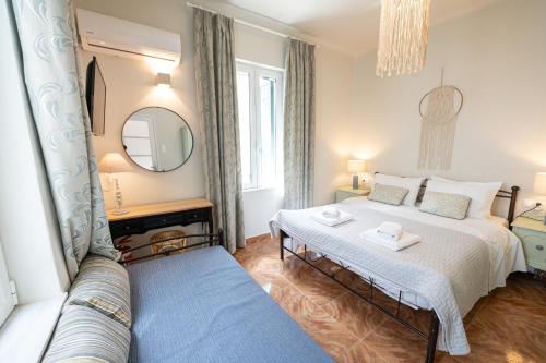 a bedroom with two beds and a couch at Sunny yard apartments in Poros