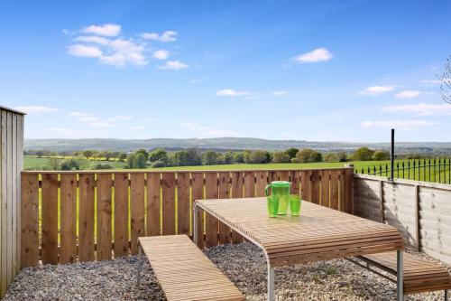 a wooden table and two chairs on a wooden deck at 2 Bed Cottage with Garden & Stunning Field Views in Durham