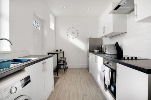 a white kitchen with a sink and a counter at 2 Bed Cottage with Garden & Stunning Field Views in Durham