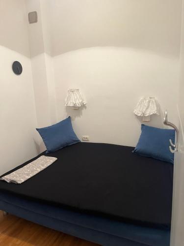 a black bed with blue pillows in a room at Risinium sun in Risan