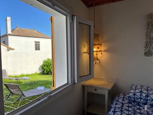 a room with a window and a bed and a chair at Casa La Finca in Vigo