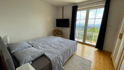 a bedroom with a bed and a large window at Vineyard cottage SkyView in Semič