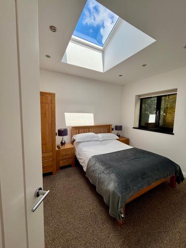 a bedroom with a large bed with a skylight at Hodder Cottage in The Ribble Valley in Whalley