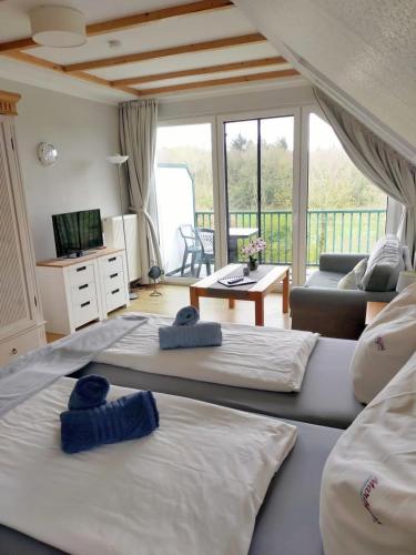 two beds in a room with a living room at Marbijes Appartementhaus in Cuxhaven