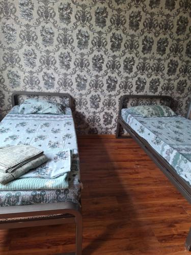 two beds in a room with a wall at сой333 in Navoi