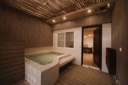 a jacuzzi tub in a room with a television at Tainan Sunwood B&B in Anping