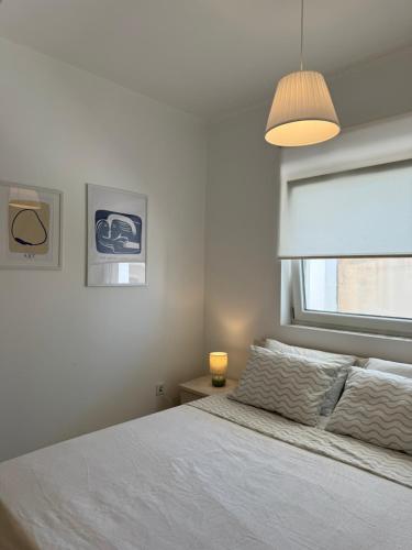 a bedroom with a white bed and a window at Maison Soleil II in Kastro Kyllini